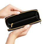 Hand holding a black wallet with gold zipper on a white background