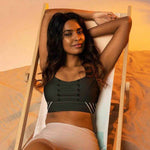 Model in black high impact longline sports bra relaxing on a beach chair | Our Phoenix Rise
