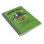 Closed spiral notebook lying flat on a surface. Shows the vibrant adventure-themed cover design and durable metal wire binding from a high angle.